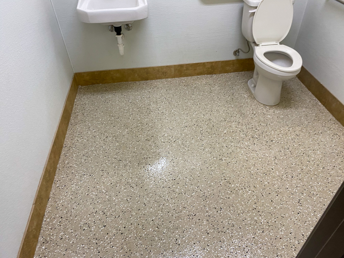 Tan concrete epoxy coating in a bathroom